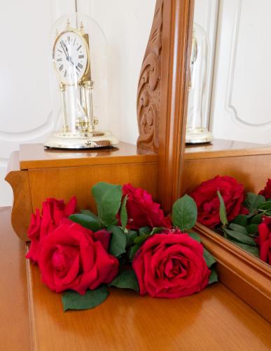 a bunch of red roses sitting next to a mirror at MANDO PATRASSO - Clasical apartment in the center of Patras with free parking in Patra