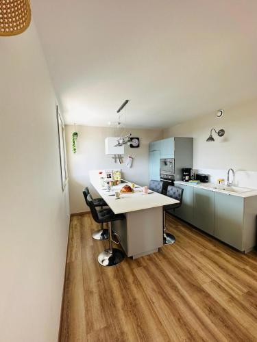 une cuisine avec un comptoir blanc et une table dans l'établissement Résidence la salle, à Perros-Guirec