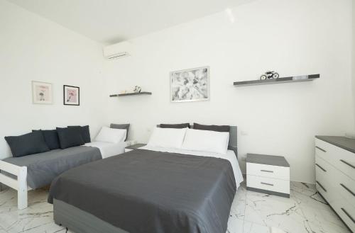 a white bedroom with a bed and a couch at Free Parking Elmi - due passi dal Lago Maggiore in Arona