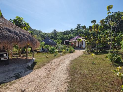 una strada sterrata che porta a un villaggio con un edificio di See the sea eco Homestay a Patiala Bawa