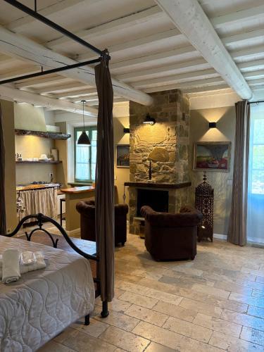a bedroom with a bed and a stone fireplace at CASA VASARI Holiday Suites TUSCANY in Lucignano