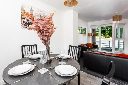 a dining room table with a vase of flowers on it at Waterfront 2 Bed Apartment - Free Parking & Wi-Fi in Preston