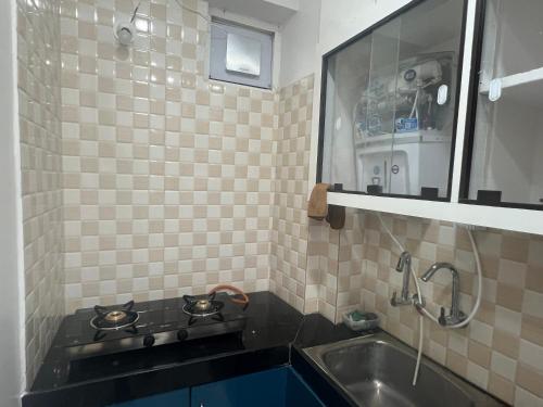 a small kitchen with a sink and a mirror at Atlas Homes 1BHK HomeStays in Hyderabad