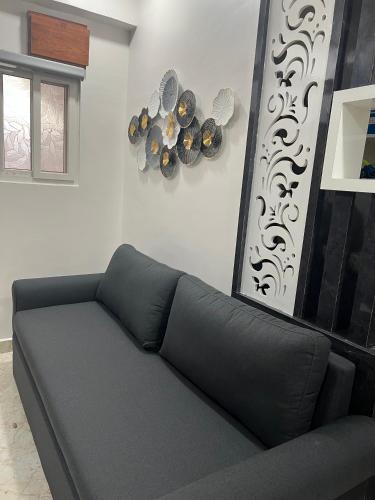 a black couch in a living room next to a wall at Atlas Homes 1BHK HomeStays in Hyderabad
