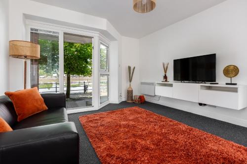 a living room with a couch and a flat screen tv at Waterfront 2 Bed Apartment - Free Parking & Wi-Fi in Preston
