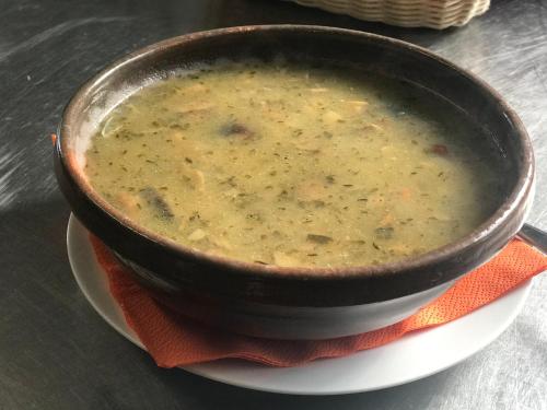 a bowl of soup on a plate on a table at Planinski dom - Mihov dom na Vršiču in Kranjska Gora