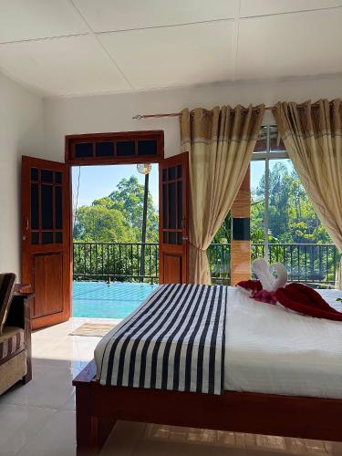 a bedroom with a bed and a large window at Liana Guest House Ella in Ella