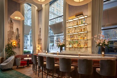 un bar dans un restaurant avec une grande fenêtre dans l'établissement The Wall Street Hotel by Suiteness, à New York