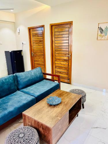 un salon avec un canapé bleu et une table basse dans l'établissement Shore and More - 7 Mins Walk to the Benaulim beach, à Benaulim