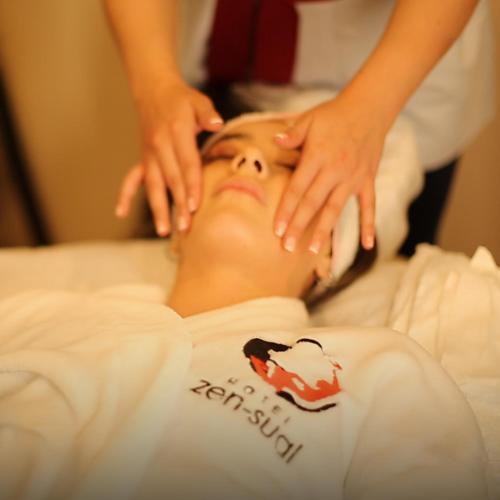 a woman is getting her face examined by a massage therapist at Hotel Zensual in Bogotá