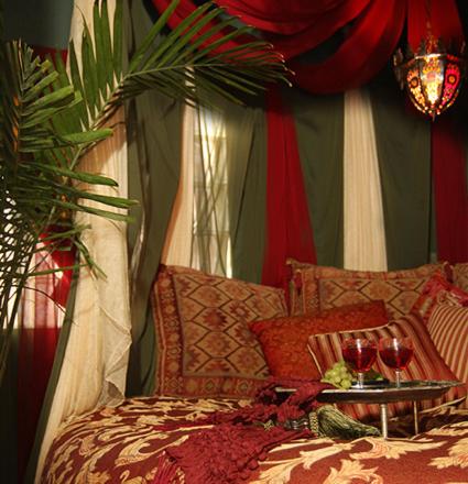 a bed with a table and two glasses of wine at El Morocco Inn & Spa in Desert Hot Springs