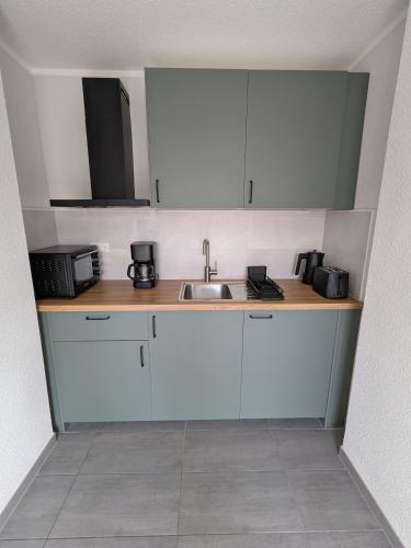 a kitchen with white cabinets and a sink at Ferienwohnung Dorfaue in Lauta