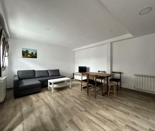 een woonkamer met een bank en een tafel bij Apartamentos El Calleral in Villahormes