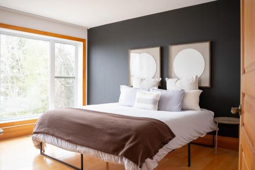 a bedroom with a large bed with two mirrors above it at Au Sommet du Lac Magog in Magog-Orford