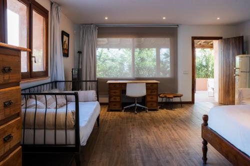 ein Schlafzimmer mit zwei Betten und einem Schreibtisch und einem Fenster in der Unterkunft Can Calyssa Luxury Villa Near City Center in Ibiza-Stadt