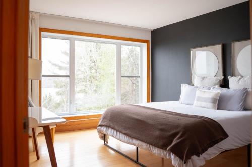 a bedroom with a large bed and a window at Au Sommet du Lac Magog in Magog-Orford
