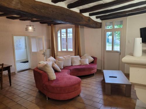un salon avec deux canapés rouges et une table dans l'établissement Maison de campagne le Joncher, à Chouzé-sur-Loire