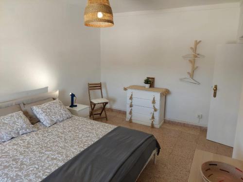 a bedroom with a bed and a chair and a table at Blue Dragon River House in Odeleite