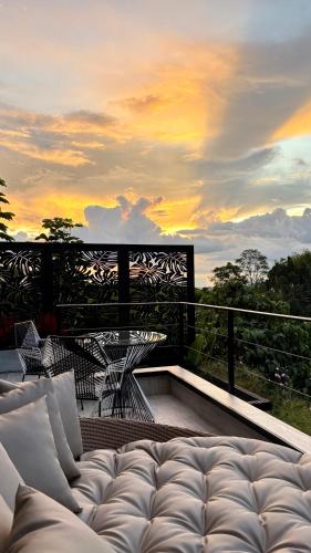 a couch sitting on a balcony with a sunset at La Font Ecolodge in Buenavista