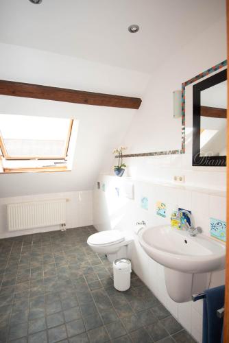 a white bathroom with a sink and a toilet at Ferienwohnung in Xanten auf dem Moerenhof in Xanten