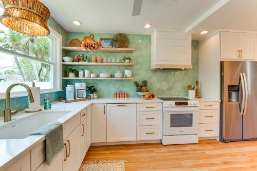 a kitchen with white cabinets and a sink at Walk to Gulf Luxe Luau-Themed Gem in Holmes Beach in Holmes Beach