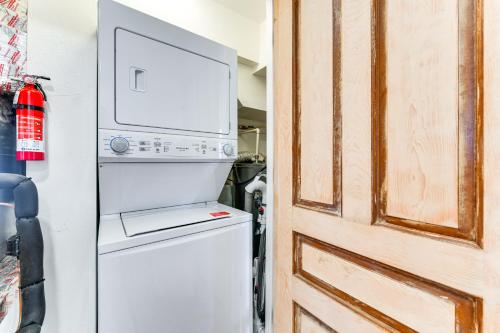 a refrigerator next to a door with a microwave at Walk to Gulf Luxe Luau-Themed Gem in Holmes Beach in Holmes Beach