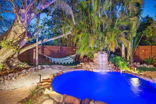 a swimming pool in a backyard with palm trees at Walk to Gulf Luxe Luau-Themed Gem in Holmes Beach in Holmes Beach