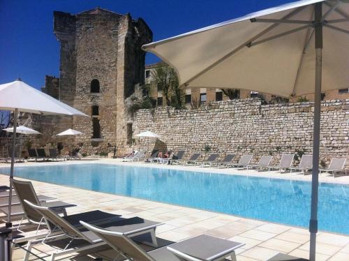 - une piscine avec des chaises et des parasols à côté d'un bâtiment dans l'établissement Apparemment hypercentre Aix-en-Provence, à Aix-en-Provence