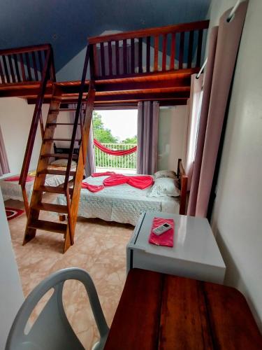 a small room with a bunk bed and a table at Pousada Chacara Cururu in Alter do Chao