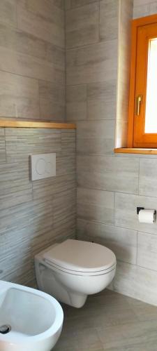 a bathroom with a white toilet and a sink at CA' DEL PITUR Apartments B&B Cicogna in Cicogna