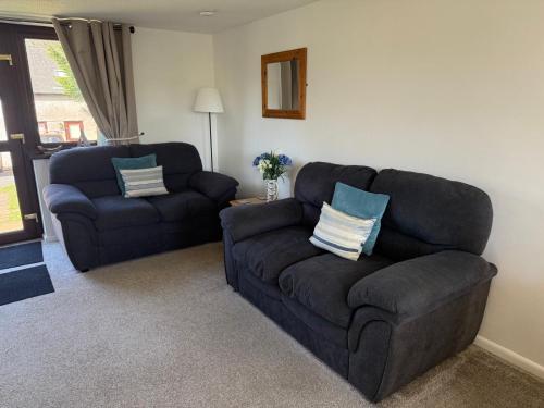 a living room with a couch and a chair at Cosy cottage between Penzance and St Ives in Gulval