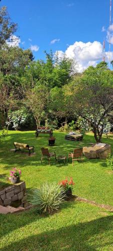a park with benches and flowers in the grass at Locanda Montecielo Pousada Boutique - Vale dos Vinhedos in Bento Gonçalves