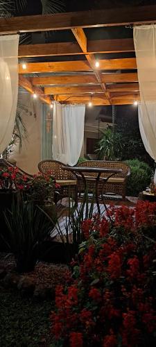 a patio with a table and chairs and flowers at Locanda Montecielo Pousada Boutique - Vale dos Vinhedos in Bento Gonçalves