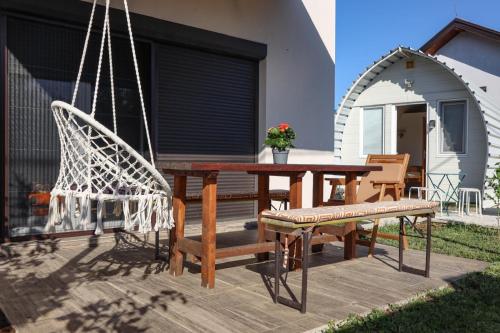 a patio with a table and chairs and a swing at Villa Lyra in Trebinje