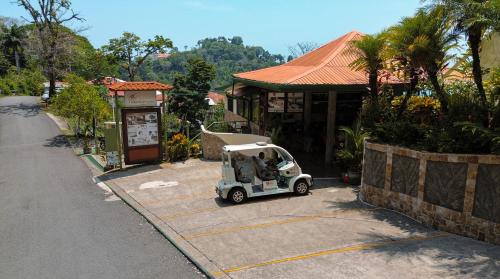 a small golf cart parked in front of a building at Issimo Suites (Adults Only) in Manuel Antonio