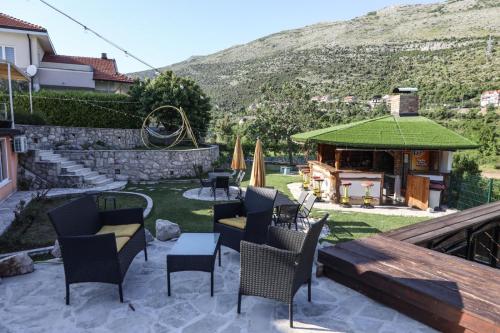 a patio with chairs and a gazebo with a grill at Villa Lyra in Trebinje