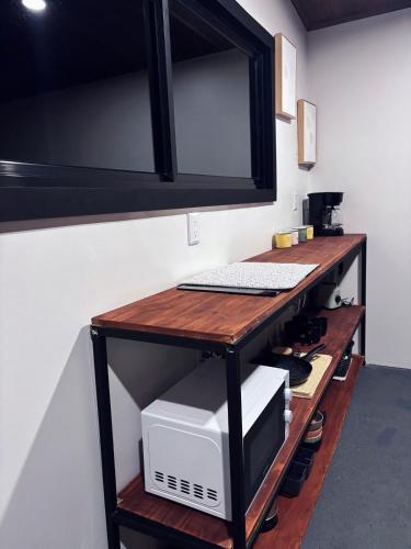 a desk with a microwave and a computer on it at Cabaña Las Brumas del Jaular in Tapantí