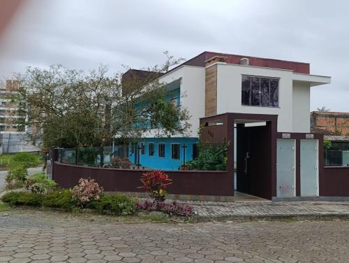 a house with a blue and white at Residencial Luce Del Sole Apt 3 in Joinville