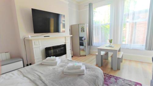 a living room with a bed with towels on it at Stylish York Studio in York