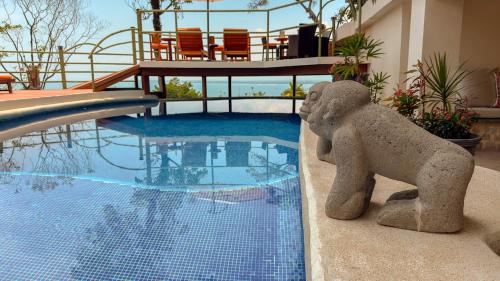 a statue of an elephant next to a swimming pool at Issimo Suites (Adults Only) in Manuel Antonio