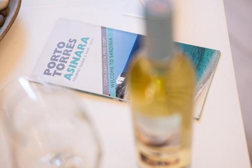 a bottle of wine on a table with a credit card at Domo Libius - Casa Vacanze By Faendho - in Porto Torres