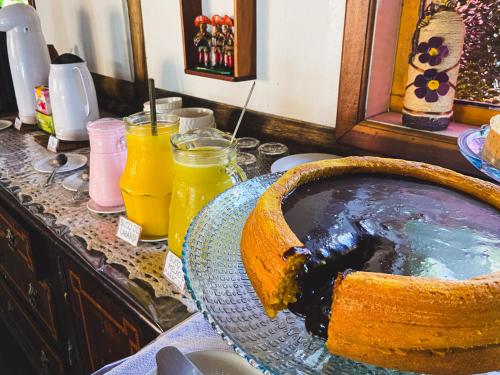 ein Kuchen in einer Schüssel auf einer Theke mit Getränken in der Unterkunft VELINN Pousada Gaia Gardens in Paraty