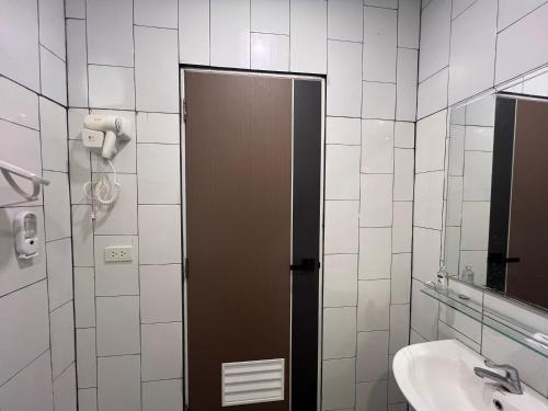 a bathroom with a brown door and a sink at Anda Mantham Hill in Ban Bang Rong