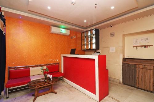 a waiting room with a red couch and a table at Xpress Inn in Garui