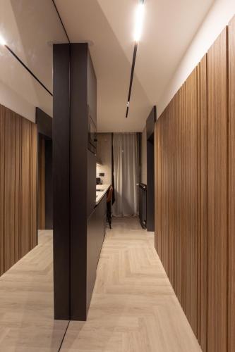 a hallway with wood paneled walls and a kitchen at Open Space in Niš