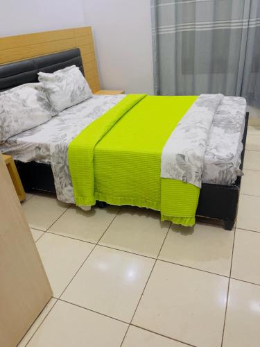 a bed with a yellow blanket on it in a room at ARSENE ACCOMODATION AT Kwetu&Venus KIGALI in Kigali