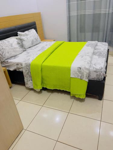 a bed with a yellow blanket on it in a room at ARSENE ACCOMODATION AT Kwetu&Venus KIGALI in Kigali