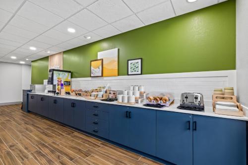 a cafeteria with blue cabinets and a green wall at Spark by Hilton Wilkes Barre in Wilkes-Barre