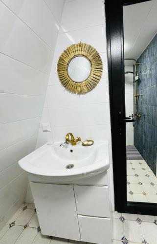 a white bathroom with a sink and a mirror at Wood Side in Tʼerjola