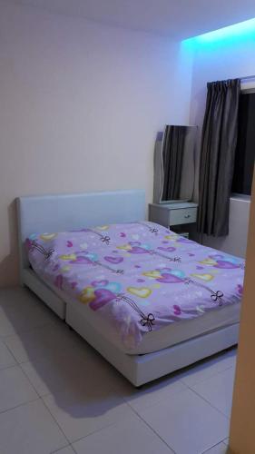 a bedroom with a bed with a pink comforter at Rose Apartment Kea Farm in Cameron Highlands
